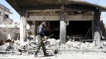 A member of al Qaeda's Nusra Front walks at a site hit by what activists said was an airstrike by forces loyal to Syria's President Bashar al-Assad in Idlib city April 14, 2015. (Reuters)