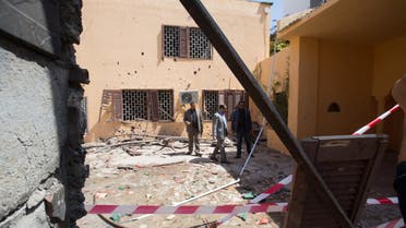 Officials survey the grounds of the the Moroccan Embassy in Tripoli, Libya after a bomb left in a garbage bin exploded on Monday, April 13, 2015. (AP)