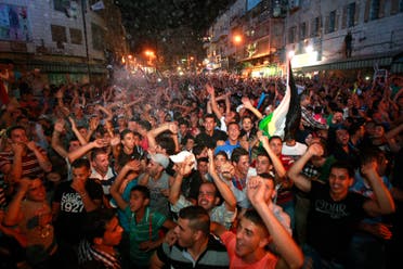 Palestinians celebrate after Palestinian singer Mohammed Assaf won a regional TV singing contest, in the West Bank city of Ramallah, Saturday, June 22, 2013. (AP)
