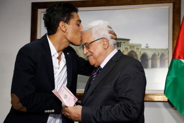 Arab Idol Mohammed Assaf, left, kisses Palestinian President Mahmoud Abbas as he hands him a diplomatic Palestinian Authority passport during their meeting in the West Bank city of Ramallah, Monday, July 1, 2013. (AP)