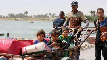 Children sit in a trolley as displaced people from Ramadi cross Bzabz bridge 65 km west of Baghdad, Iraq, Saturday, April 18, 2015. (AP)