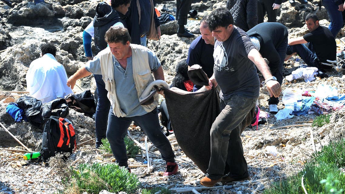 Men carry a dead body inside a blanket on the shore in the eastern Aegean island of Rhodes,Greece on Monday, April 20, 2015 .Greek authorities said that at least three people have died, including a child, after a wooden boat carrying tens migrants from ran aground off the island of Rhodes. (AP Photo//Nikolas Nanev)