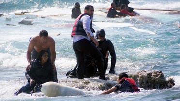 A man rescues an migrant from the Aegean sea, in the eastern island of Rhodes, Monday, April 20, 2015. (AP)