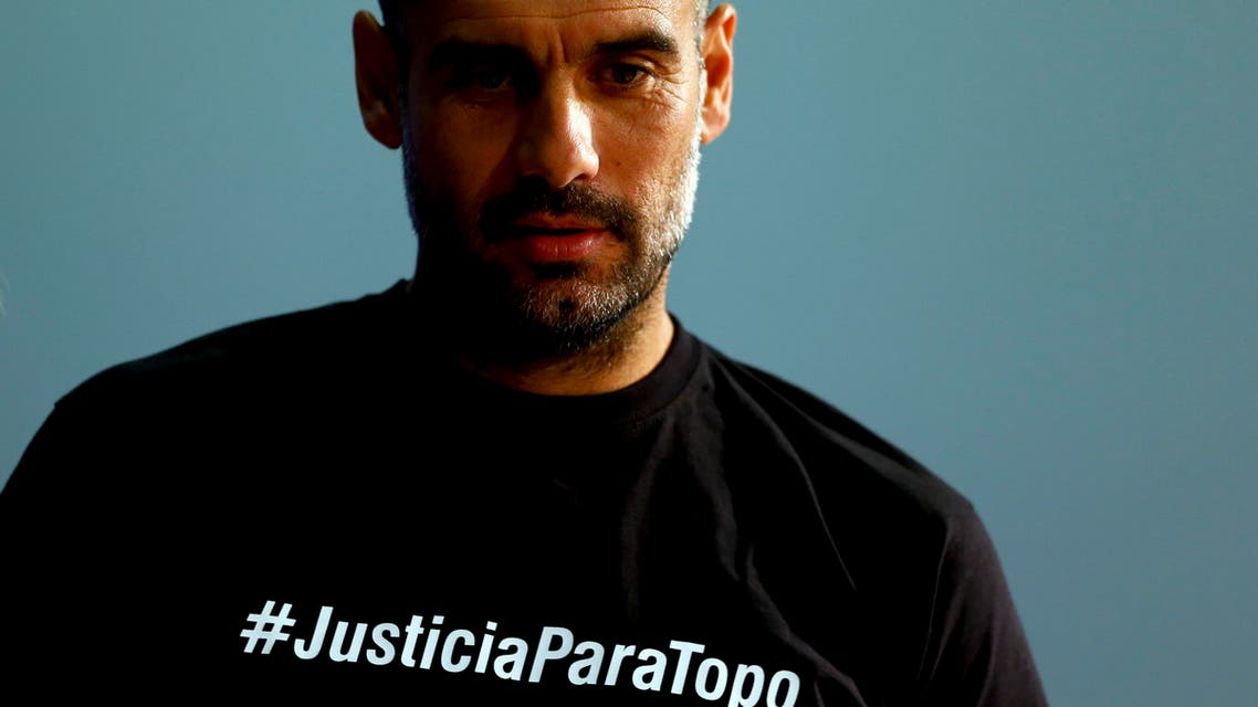 Bayern's head coach Pep Guardiola from Spain wears shirt remembering killed sport journalist Julio ‘Topo’ Lopez as he arrives for a news conference prior to the Champions League quarterfinal second leg soccer match between FC Bayern Munich and FC Porto at Allianz Arena in Munich, southern Germany, Monday, April 20, 2015. Munich will face Porto Tuesday. (AP Photo/Matthias Schrader)