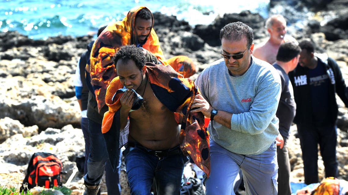 A Greek man helps a migrant to leave shore in the eastern Aegean island of Rhodes, Greece on Monday, April 20, 2015 .Greek authorities said that at least three people have died, including a child, after a wooden boat carrying at least 83 migrants from the Turkish shore ran around off the island of Rhodes. (AP Photo//Nikolas Nanev)