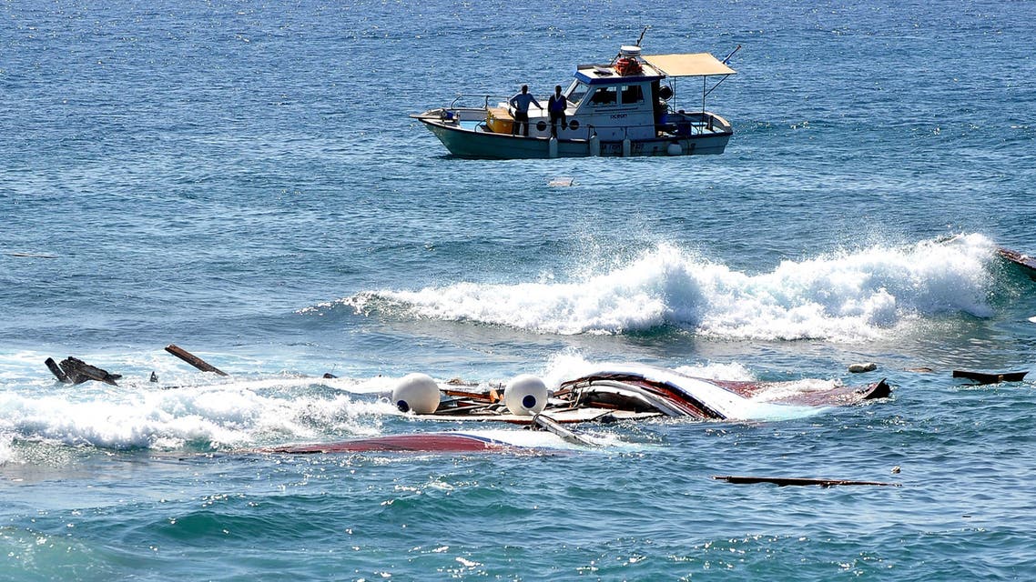 A Monday, April 20, 2015 photo from files showing fishermen looking at the wreckage of a boat which was carrying dozens of immigrants in the eastern Aegean island of Rhodes, Greece. (AP)