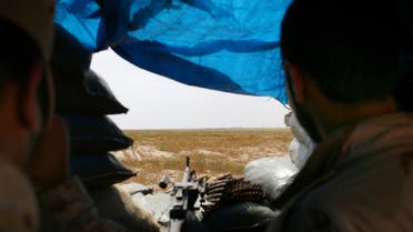 In this Monday, April 20, 2015 photo, two Sunni fighters overlook an ISIS group-held village on the other side of the frontline in northern Iraq. (AP)
