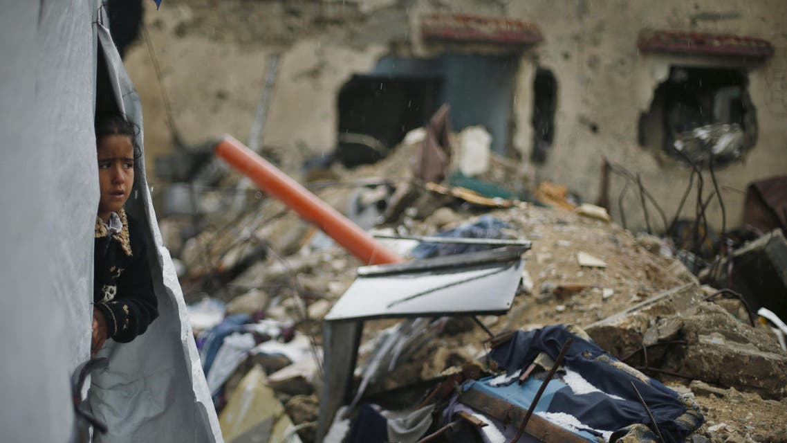 A Palestinian girl looks out of a tent erected near the remains of her family's house that witnesses said was destroyed by Israeli shelling during the 50-day war in the summer of 2014, on a rainy day in Beit Hanoun town in the northern Gaza Strip April 12, 2015. Reuters