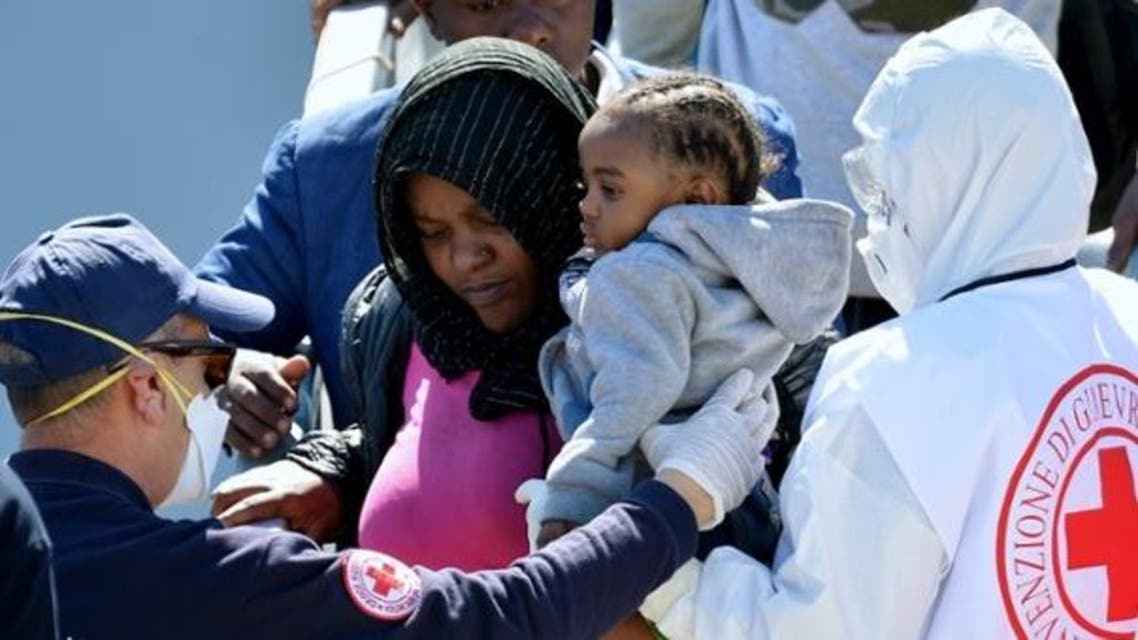 Rescued migrants are helped from an Italian navy ship AFP