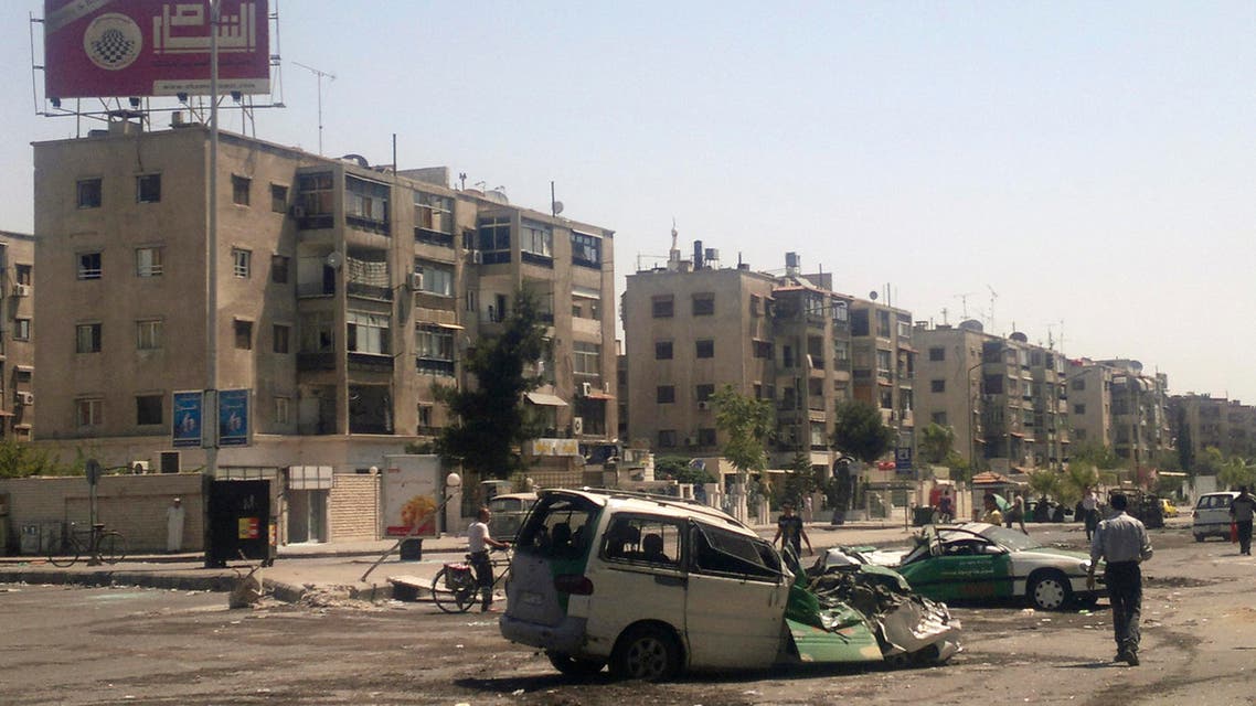 This Saturday, July 21, 2012 citizen journalist file image shows Syrians walking past destroyed vehicles after fighting between rebels and Syrian troops in the Yarmouk camp for Palestinian refugees in south Damascus, Syria. On Saturday, April 4, 2015, Syrian activists said that Islamic militants have taken over the majority of neighborhoods in the Palestinian refugee camp on the edge of Damascus as fighting continues for the fourth day. (AP Photo, File)