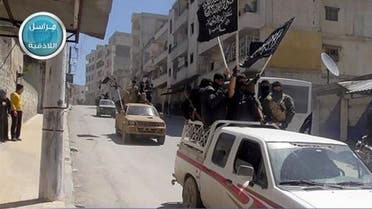 Nusra Front fighters standing on their vehicles and waving their group's flags as they tour the streets of Jisr al-Shughour, Idlib province, Syria. (AP)