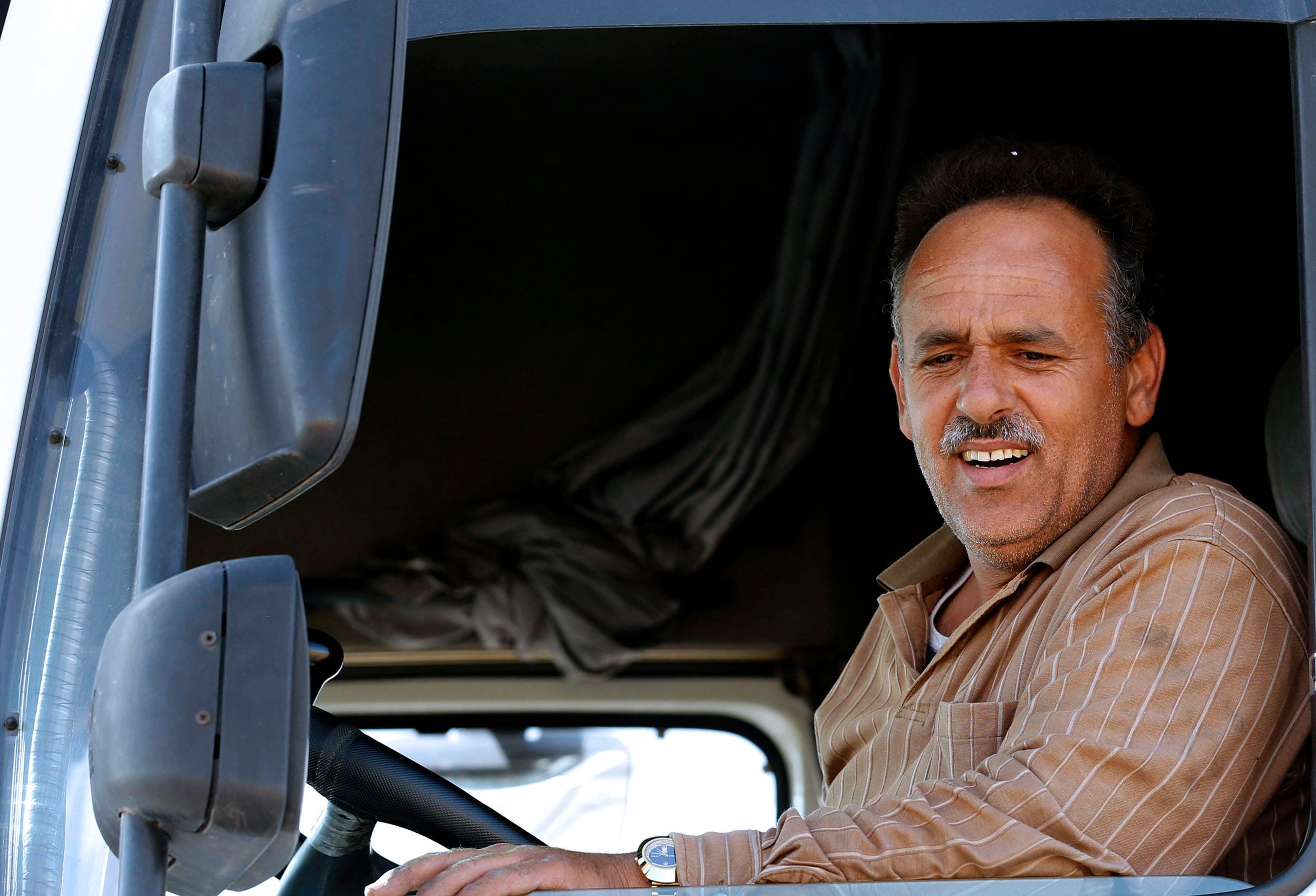 In this Sunday, April 26, 2015, photo, Jordanian trucker Firas Zoabi, 39, drives out of a free trade zone next to the closed Syrian-Jordanian cargo crossing in Mafraq, Jordan. “Iraq is closed, Syria is closed, only the (route to the) Gulf is left,” said Zoabi, who has lost most of his business in recent weeks because of blocked or treacherous crossings. (AP Photo/Raad Adayleh)