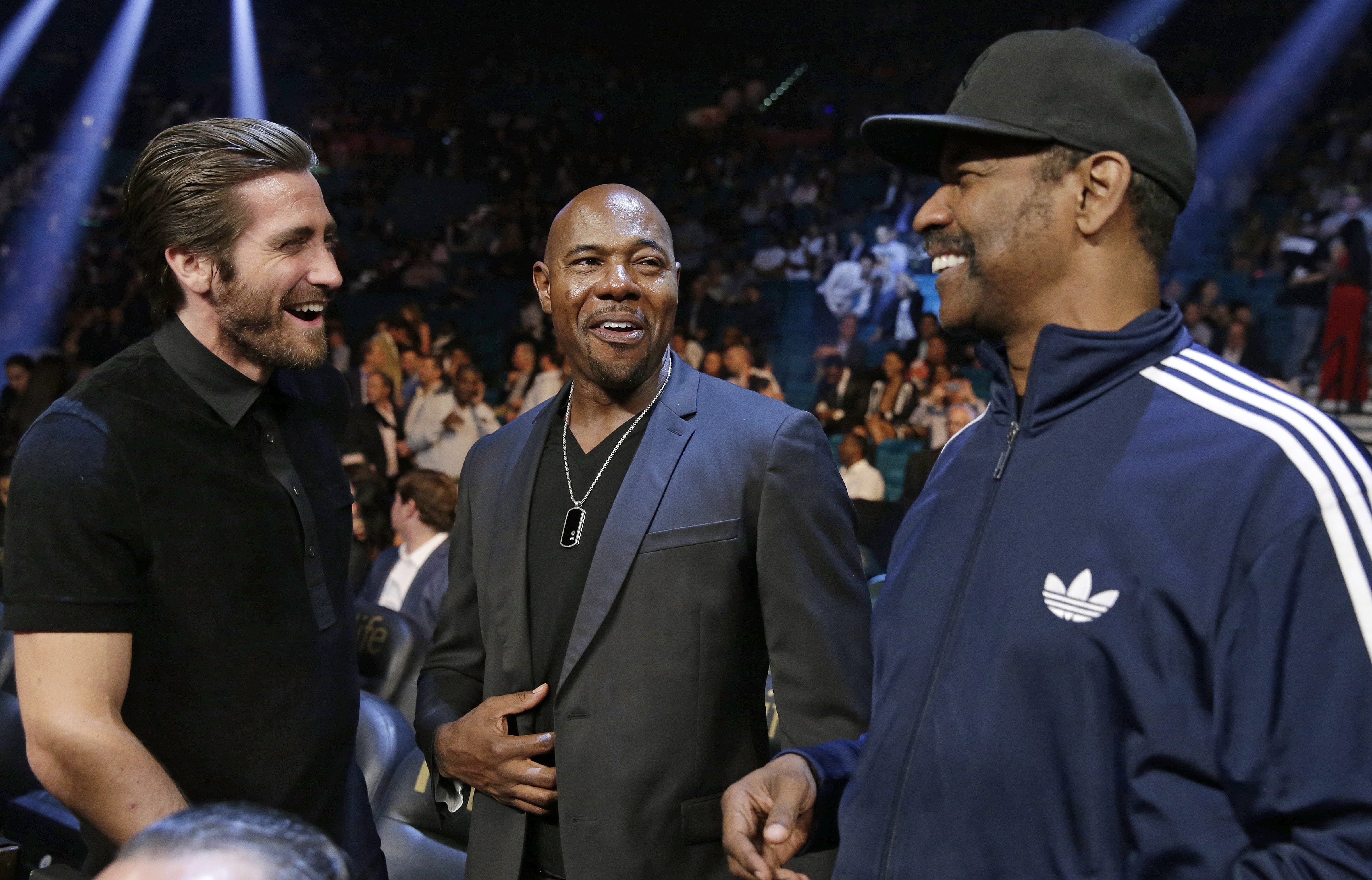 Actor Jake Gyllenhaal, left, is joined by director Antoine Fuqua and actor Denzel Washington before the start of the world welterweight championship. (AP)