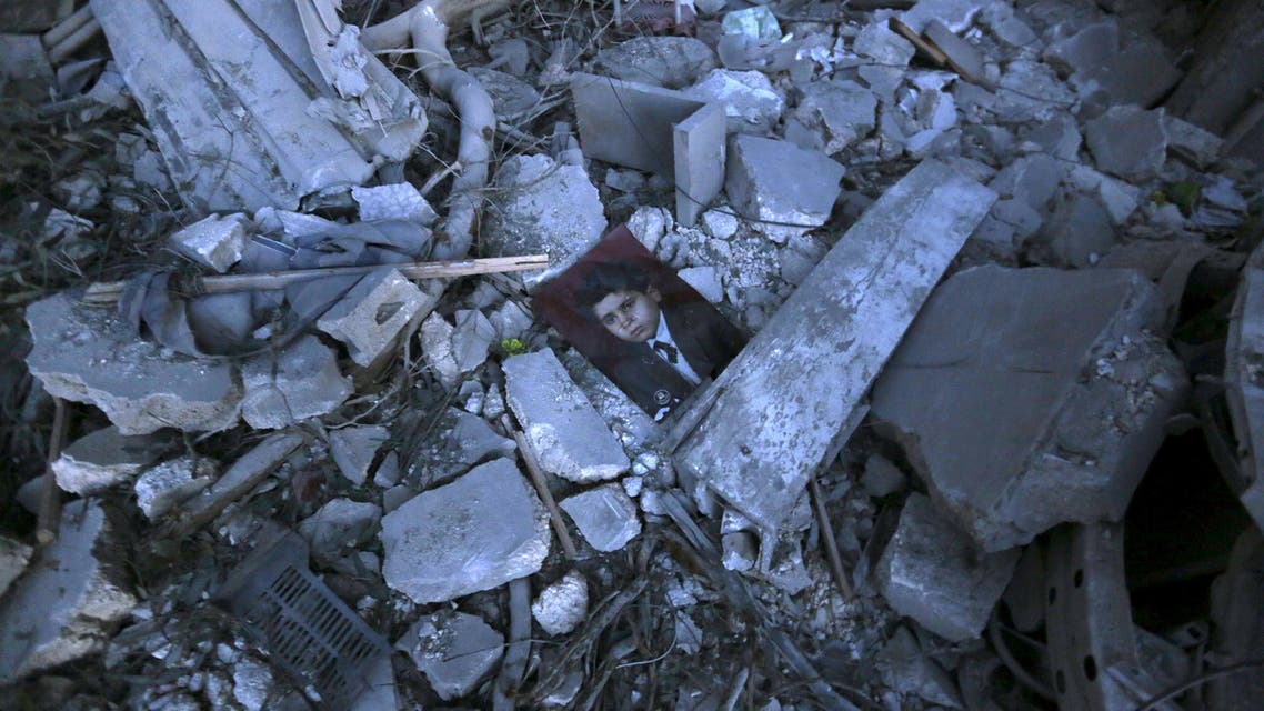 A picture lies amidst debris of collapsed buildings after what activists said was a barrel bomb dropped by forces loyal to Syria's President Bashar al-Assad in the Al-Qatrgi neighbourhood of Aleppo