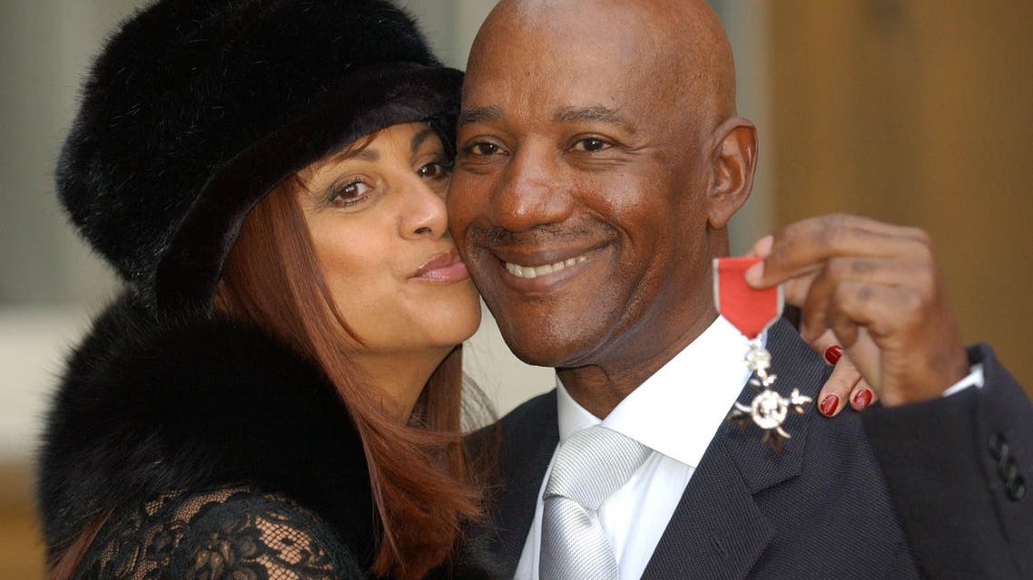 In a file picture taken on November 27, 2003 Hot Chocolate singer Errol Brown (R) with his wife Ginette after being invested as a Member of the Order of the British Empire (MBE), for services to pop music, from Queen Elizabeth II at Buckingham Palace. Errol Brown, whose funky numbers with Hot Chocolate such as "You Sexy Thing" became sensations in the disco era, died on May 5, 2015 of liver cancer. He was 71. AFP PHOTO / POOL / FIONA HANSON