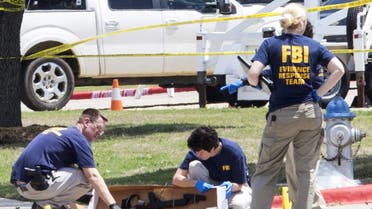 FBI investigators collect evidence, including a rifle, where two gunmen were shot dead after their bodies were removed in Garland, Texas May 4, 2015. (Reuters)