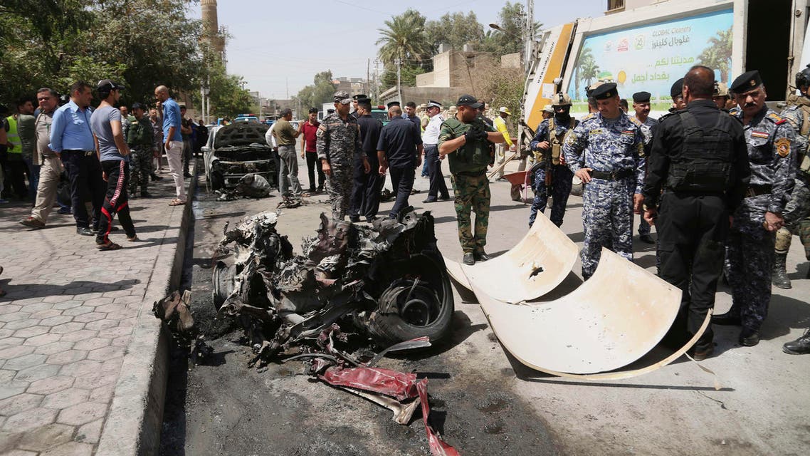 Civilians and security forces gather at the scene of a car bomb explosion near Khudairi mosque in Karrada neighborhood, Baghdad, Iraq, Tuesday, May 5, 2015. A car bomb exploded in the central Karrada commercial area killing several people, according to police and medical officials. The area where the car exploded included restaurants, shops and a Sunni mosque. (AP Photo/Khalid Mohammed)