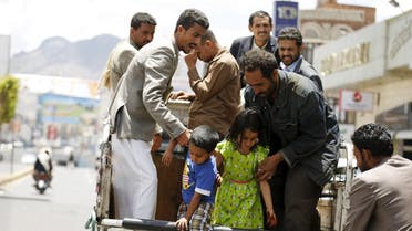 People help children step out of a truck taxi in Yemen's capital Sanaa May 6, 2015. REUTERS