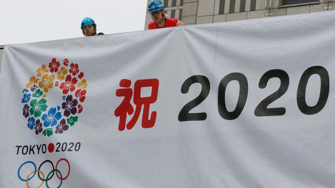 Workers hang a banner celebrating the city's successful bid to host the 2020 Summer Olympics as they prepare for an official event by the Tokyo Municipal Government to report the news to Tokyo citizens at the government office square in Tokyo Sunday morning, Sept. 8, 2013. AP 