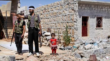 A Syrian child stands next to rebel fighters checking a house that was damaged in bombing by government forces in Marea, on the outskirts of Aleppo, Syria, Tuesday, Sept. 4, 2012. (Associated Press)