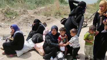 Women hold their children as displaced people from Ramadi cross Bzabz bridge 65 km west of Baghdad, Iraq, Saturday, April 18, 2015. Thousands of displaced people form Ramadi city continue to pour to Baghdad, fleeing the ongoing fighting in Anbar provincial capital between Iraqi security forces and fighters from Islamic State militant group. (AP Photo/Karim Kadim)