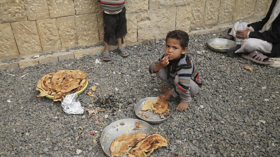 A boy eats with other internally displaced people in a school in the district of Khamir of Yemen's northwestern province of Amran