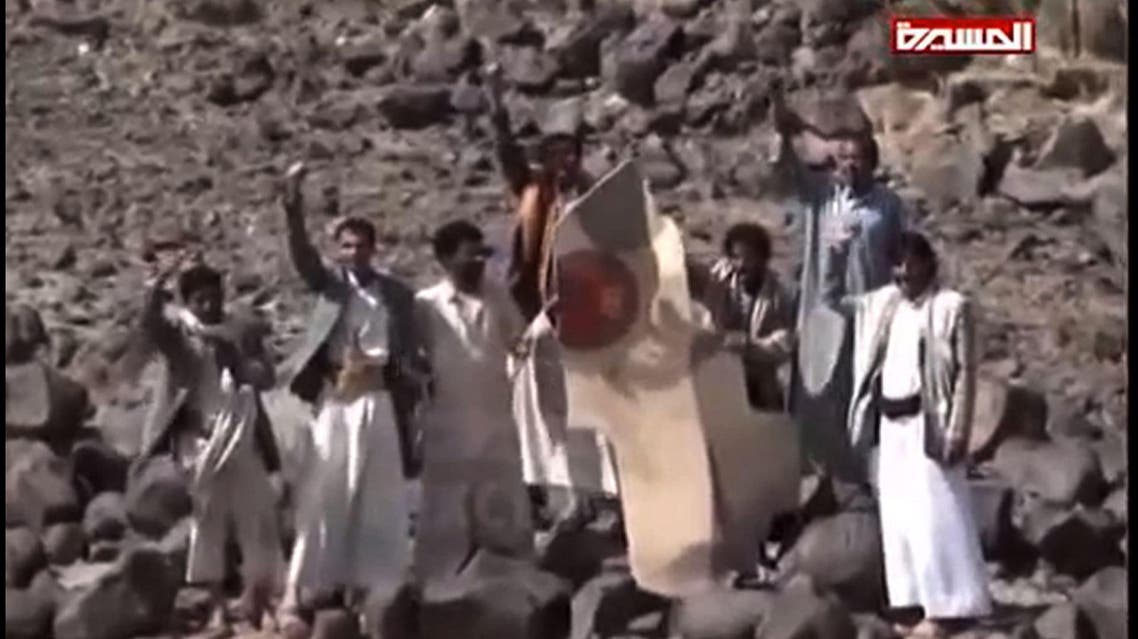 An image grab taken from the Huthi rebel television station Al-Masira shows Yemeni tribesmen celebrating around the wreckage of a plane bearing a Moroccan flag, in the the Wadi Nushur area in the north Yemen's province of Saada, on May 11, 2015. Yemeni rebels said they shot down a fighter jet as Saudi-led coalition air strikes intensified a day ahead of a hoped-for five-day humanitarian truce. Morocco announced that one of its warplanes taking part in operations against the rebels was missing along with its pilot, and that a search was underway.
