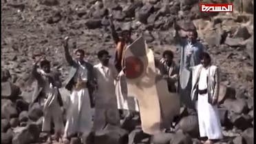 An image grab taken from the Huthi rebel television station Al-Masira shows Yemeni tribesmen celebrating around the wreckage of a plane bearing a Moroccan flag, in the the Wadi Nushur area in the north Yemen's province of Saada, on May 11, 2015. Yemeni rebels said they shot down a fighter jet as Saudi-led coalition air strikes intensified a day ahead of a hoped-for five-day humanitarian truce. Morocco announced that one of its warplanes taking part in operations against the rebels was missing along with its pilot, and that a search was underway. 