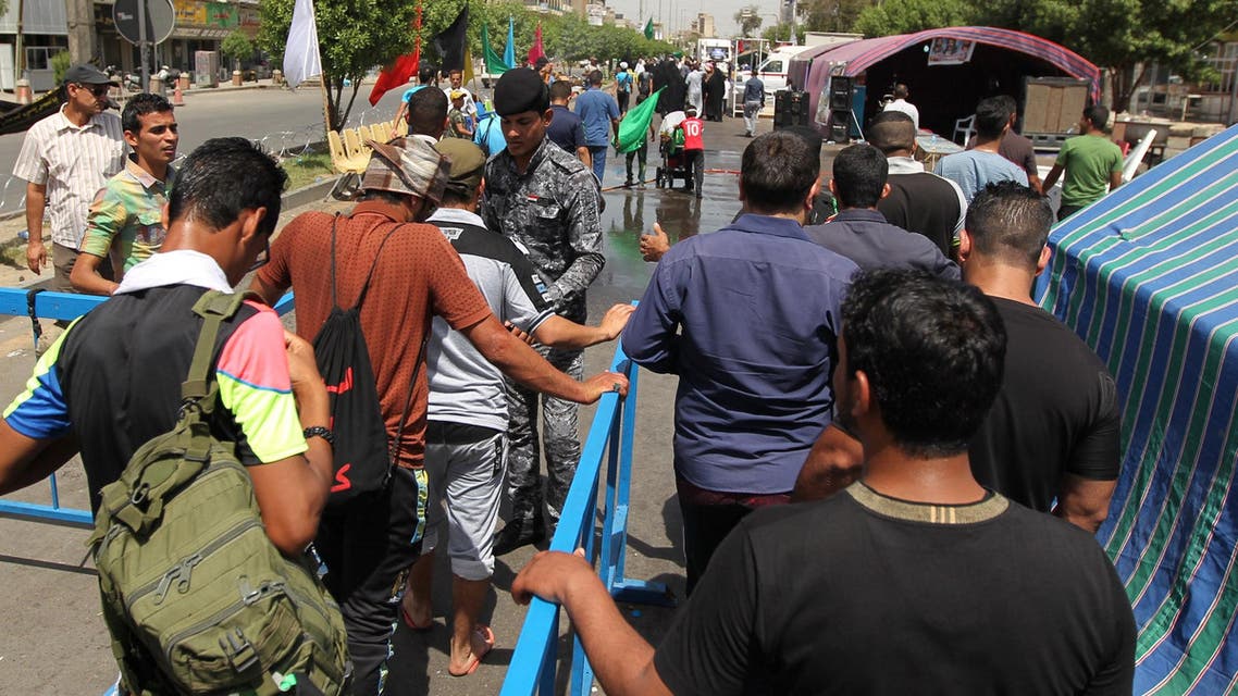 Iraqi Shiite Muslim pilgrims are searched by members of the security forces as they head to the Imam al-Kadhim shrine in Baghdad, on May 12, 2015, for a commemoration ceremony. (AFP)