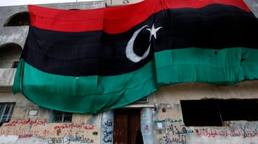 A Libyan woman steps inside a building which is dressed with a huge old Libyan flag, in Benghazi, eastern Libya, on Friday March 4, 2011. (AP)