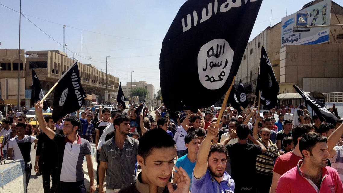 In this Monday, June 16, 2014 file photo, demonstrators chant pro-Islamic State group slogans as they wave the group's flags in front of the provincial government headquarters in Mosul, 225 miles (360 kilometers) northwest of Baghdad, Iraq. The IS declaration of a "caliphate" in Iraq and Syria inspired a stream of thousands of foreign fighters to join it and earned it pledges of allegiance by individual militants around the region. (AP Photo, File)