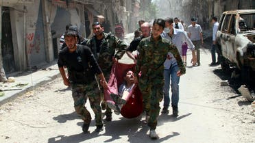 Rescuers carry a man wounded by a mine that went off in Homs, Syria. AP 