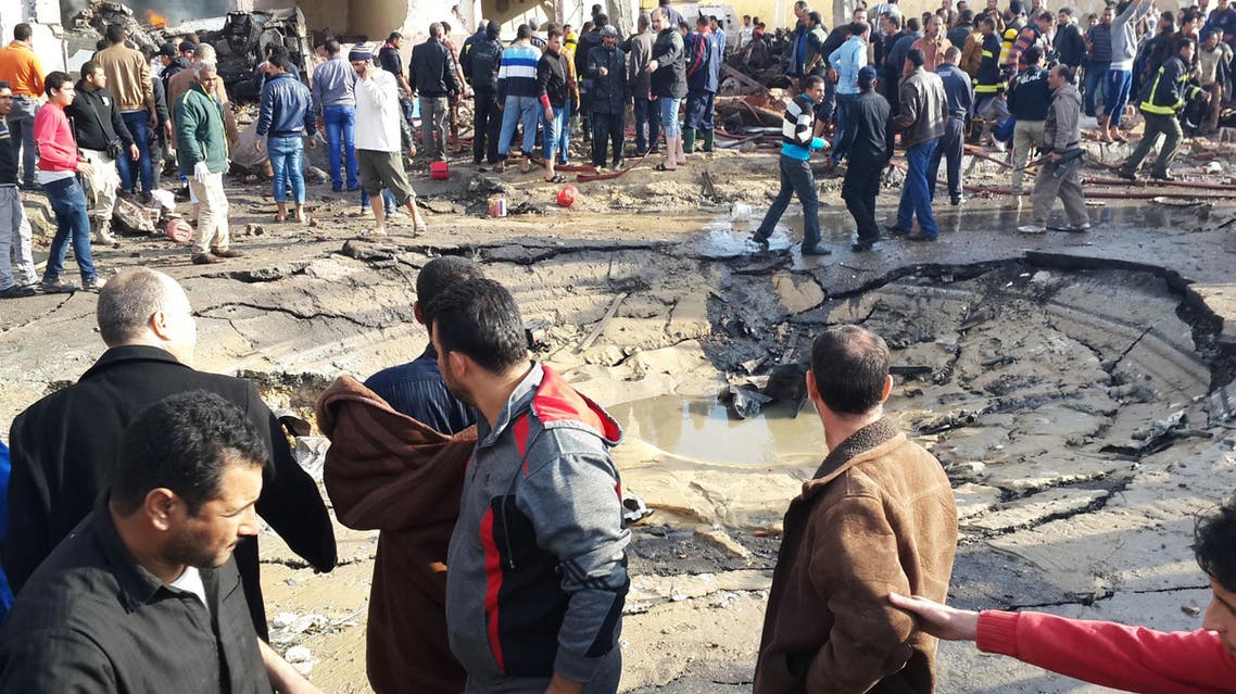 Egyptians gather around the crater following a bombing that struck a main police station in the capital of the northern Sinai province in el-Arish, Egypt, Sunday, April 11, 2015. The explosion comes hours after a roadside bomb killed six soldiers traveling south of el-Arish in an armored vehicle. The region has been hit by an Islamic insurgency by a group that recently pledged allegiance to the Islamic State. (AP Photo/Muhamed Sabry)
