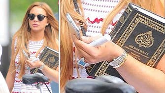 Lindsay Lohan holds the Quran as she leaves her community service