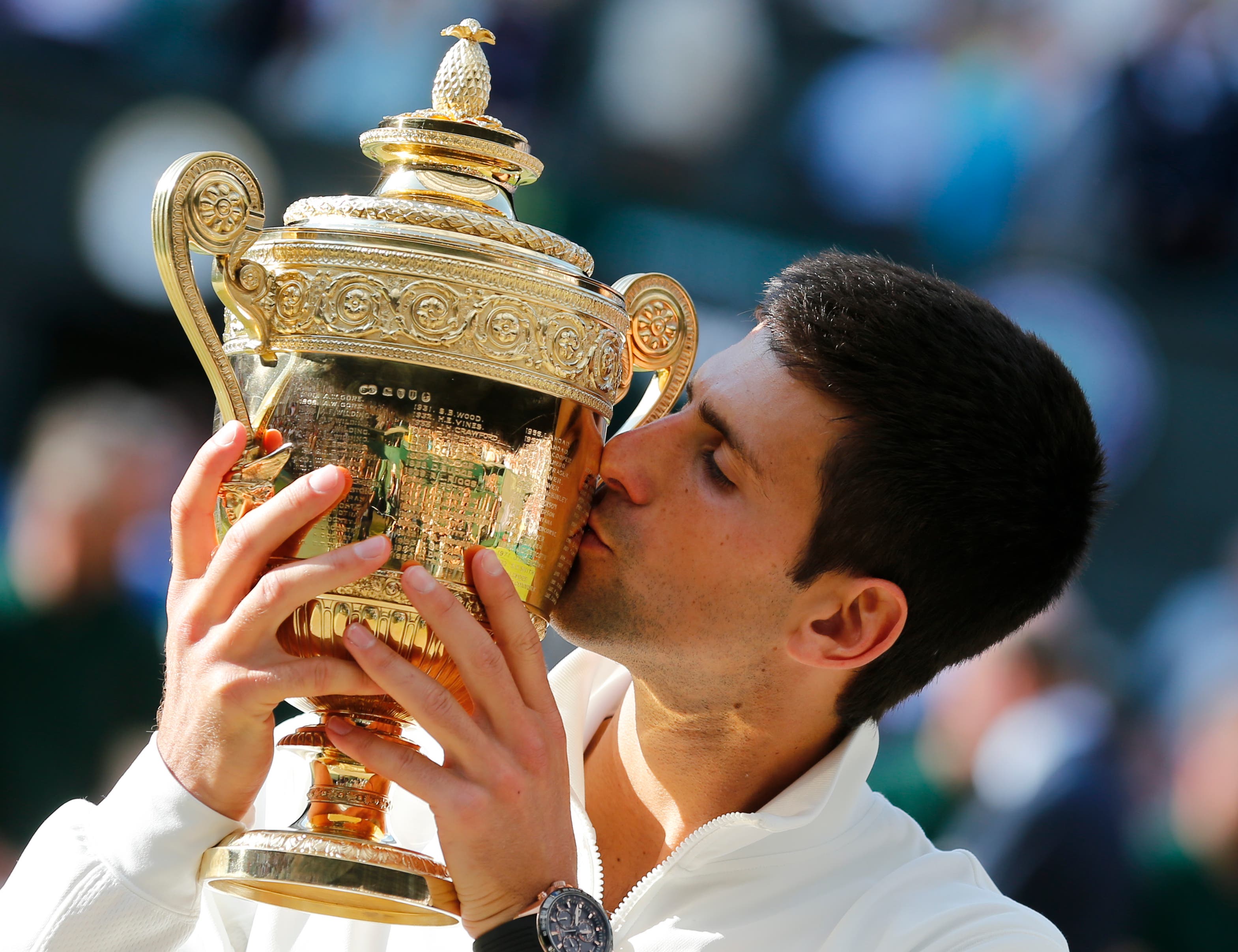 In this July 6, 2014, file photo, Novak Djokovic of Serbia kisses the trophy after defeating Roger Federer of Switzerland in the men's singles final at the All England Lawn Tennis Championships in Wimbledon, London. Heading into the U.S. Open, Roger Federer, Rafael Nadal, Djokovic and Andy Murray have won 36 of the past 38 Grand Slam titles, a stretch dating to the 2005 French Open. Nowadays, there seems to be a growing sense _ or hope, maybe _ among the best of the rest on the men's tennis tour that the quartet might be more vulnerable than ever. (AP Photo/Ben Curtis, File)