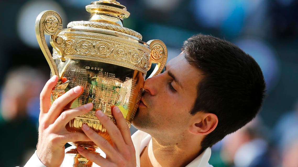 In this July 6, 2014, file photo, Novak Djokovic of Serbia kisses the trophy after defeating Roger Federer of Switzerland in the men's singles final at the All England Lawn Tennis Championships in Wimbledon, London. Heading into the U.S. Open, Roger Federer, Rafael Nadal, Djokovic and Andy Murray have won 36 of the past 38 Grand Slam titles, a stretch dating to the 2005 French Open. Nowadays, there seems to be a growing sense _ or hope, maybe _ among the best of the rest on the men's tennis tour that the quartet might be more vulnerable than ever. (AP Photo/Ben Curtis, File)