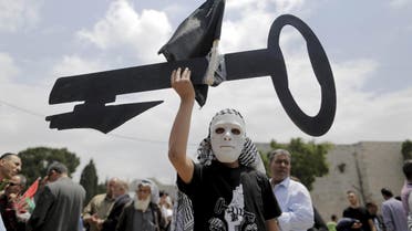 A Palestinian wearing a mask holds a cut-out of a key during a rally ahead of the Nakba day in the West Bank city of Bethlehem May 14, 2015. (File: Reuters)