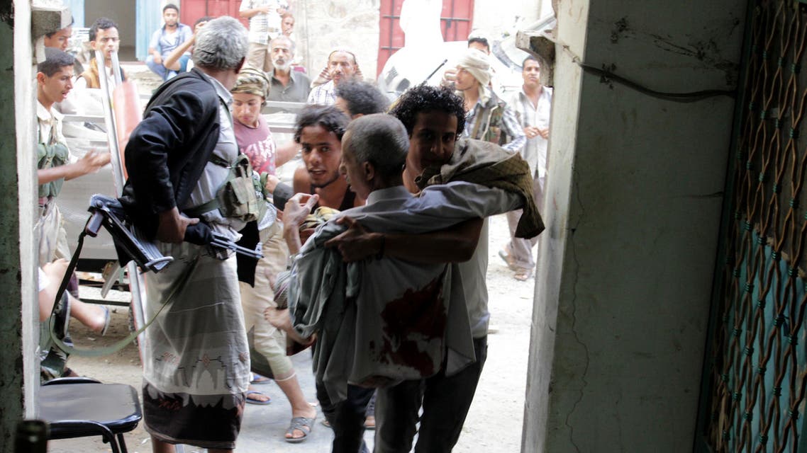 People carry a man, who was injured during a clashes between tribal fighters and Shiite militia known as Houthis, in the western city of Taiz, Yemen, Friday, May 15, 2015. Fighting was underway across Yemen on Friday, the third day of a humanitarian truce between a Saudi-led coalition and Shiite rebels, as the U.N. envoy pushed for holding peace talks in Geneva. (AP Photo/Abdulrahman Hawis)