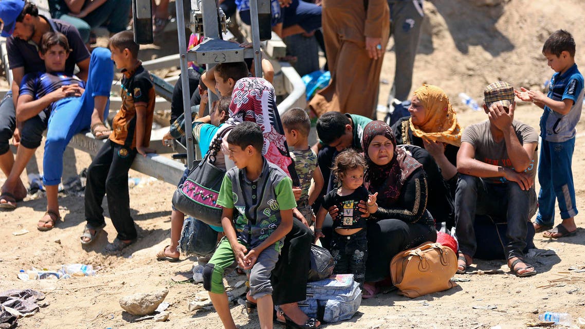Displaced Iraqis from Ramadi rest before crossing the Bzebiz bridge after spending the night walking towards Baghdad, as they flee their hometown, 65 km west of Baghdad, Iraq, Saturday, May 16, 2015. AP