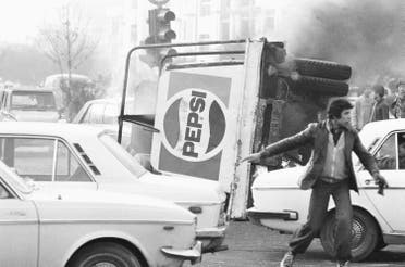 In this Dec. 27, 1978 file picture, an overturned truck with a Pepsi soft drink logo burns in the center of Tehran during riots which paralyzed the city. AP