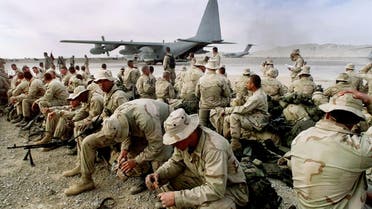 In this Jan. 22, 2002, file photo U.S. Marines sit along the runway of the airbase in Kandahar, Afghanistan, as they withdraw to be replaced by the Army's 101st Airborne division. (AP)