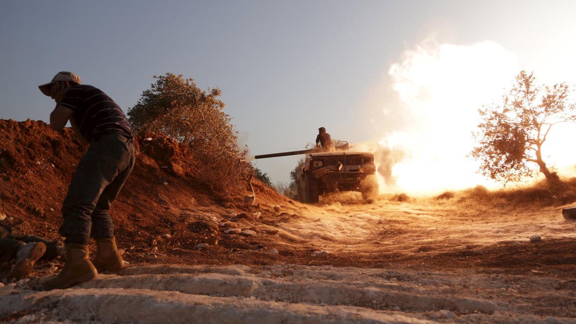 Rebel fighter fires a vehicle's weapon during what the rebels said is an offensive to take control of the al-Mastouma army base near Idlib city