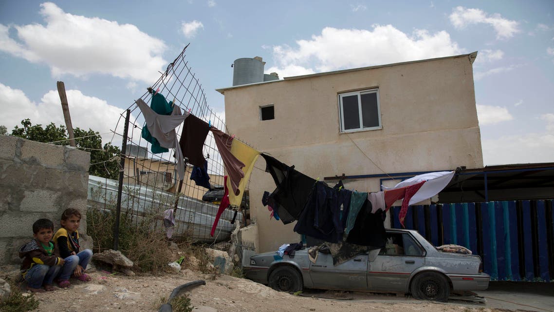 In this Tuesday, May 12, 2015 photo, Bedouin children sit outside their home in the village of Umm Al-Hiran in the Negev desert, Israel. In a landmark decision, Israel's Supreme Court has cleared the way for the government to uproot the nearly 60-year-old Bedouin Arab village of Umm al-Hiran, a dusty hill of ramshackle dwellings without proper electricity or water hookups, and in its place build "Hiran," a new Jewish community expected to feature a hotel and country club. (AP Photo/Tsafrir Abayov)