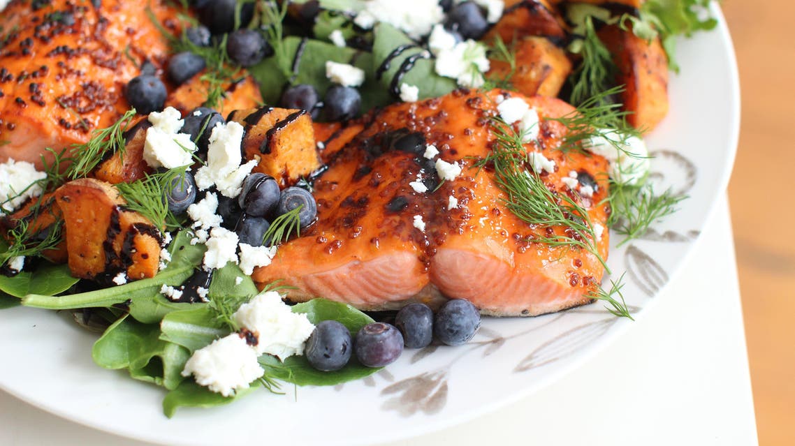 This March 16 2015 photo shows broiled sockeye salmon with blueberries and sweet potatoes in Concord, NH. (AP Photo/Matthew Mead