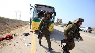 Israeli soldiers check a bus that was damaged by an anti-tank missile fired from the Gaza Strip into southern Israel on the road between kibbutz Nahal Oz and kibbutz Sa'ad April 7, 2011. (BAZ RATNER/REUTERS)
