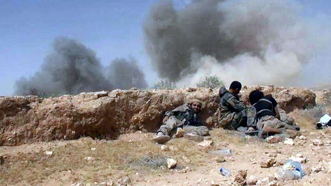 ISIS fighters take cover during a battle against Syrian government forces on a road between Homs and Palmyra, Syria. (File: AP)