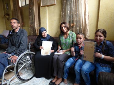 Journalist Nabila Ramdani with Fatma Hussein Omar, 67, with her son Ahmed, 37, paralysed by the Israeli army and her grandchildren Ali, 7 and Angham, 9 - holding the key and legal documents of the family home confiscated by Israel's Zionist paramilitaries in 1948. (Al Arabiya/ Nabila Ramdani)