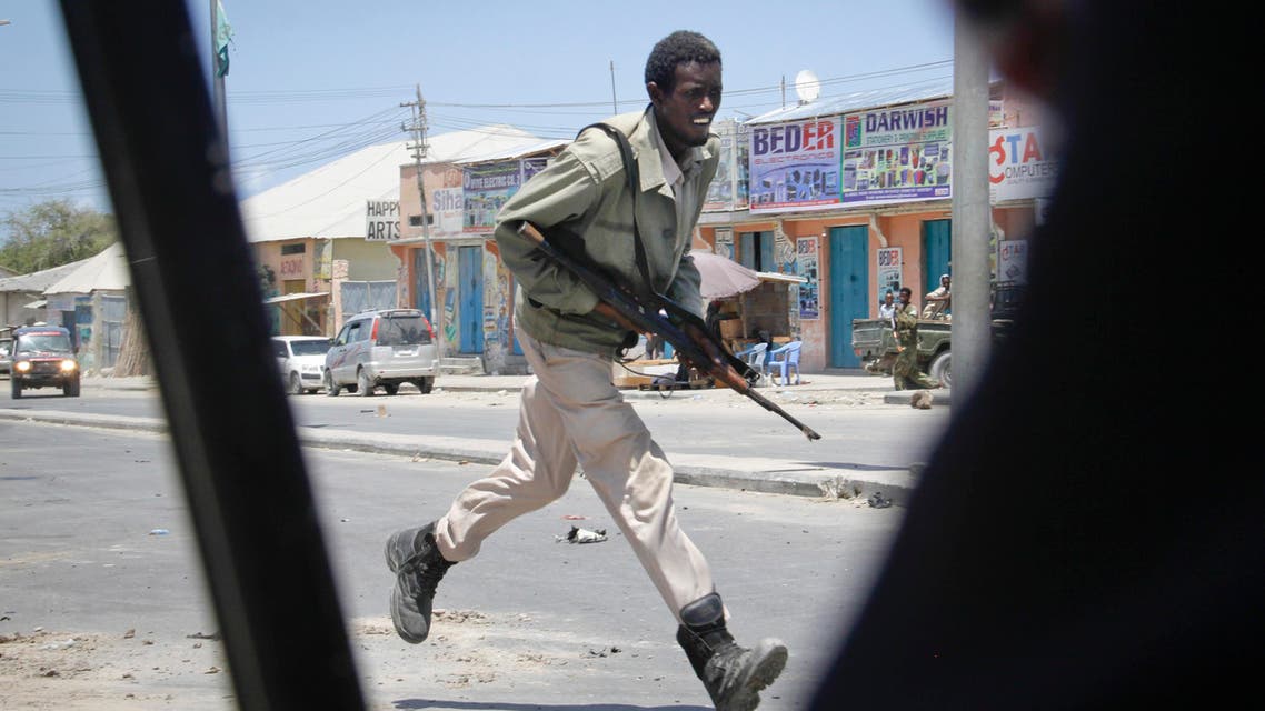 A Somali soldier runs during fighting following a car bomb that was detonated at the gates of a government office complex in the capital Mogadishu, Somalia Tuesday, April 14, 2015. (AP)