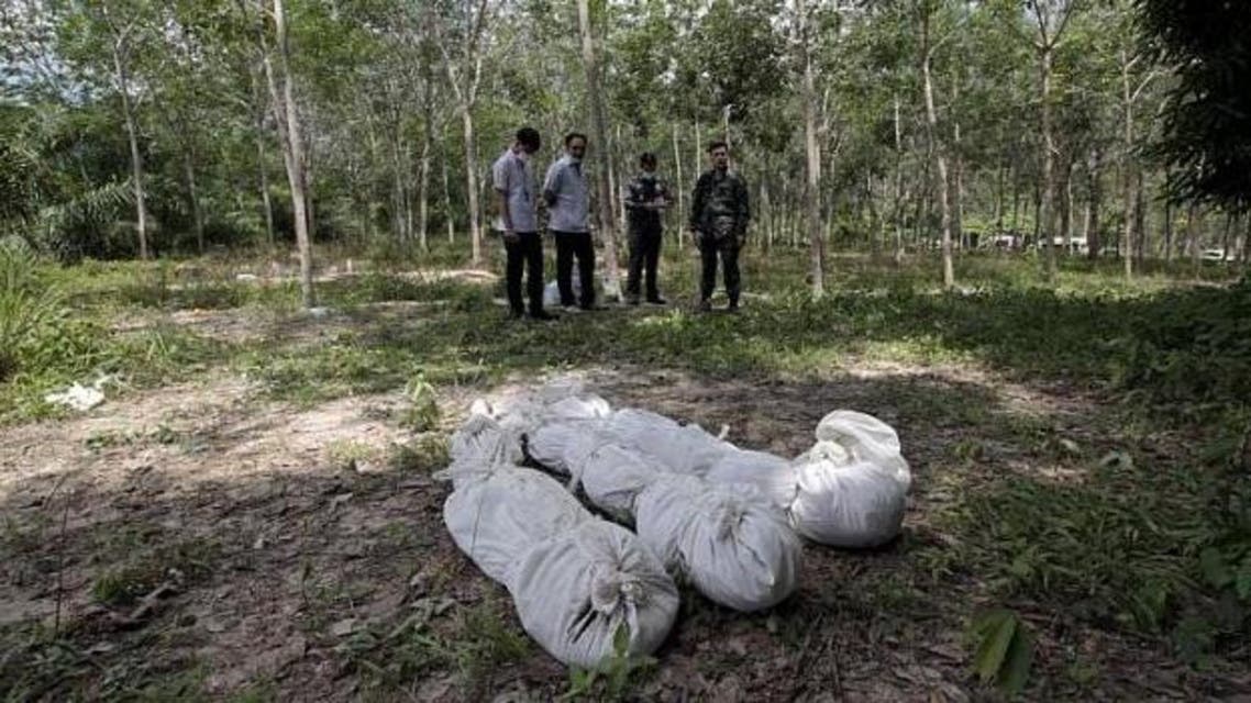 Thai policemen take notes behind human remains retrieved from a mass grave at a rubber plantation near a mountain in Thailand's southern Songkhla province on May 6, 2015. Malaysian police have discovered 30 mass graves in Perlis, believed to be linked to the mass graves found earlier this month in southern Thailand. -- PHOTO: REUTERS - See more at: http://www.straitstimes.com/news/asia/south-east-asia/story/mass-graves-hundreds-dead-immigrants-found-perlis-report-20150524#sthash.JfBK1o15.dpuf