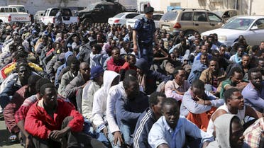Migrants sit at a detention center after they were detained by the Libyan authorities in Tripoli, Libya May 17, 2015. Libyan authorities rounded up hundreds of migrants before they could head to European shores. REUTERS/Hani Amara